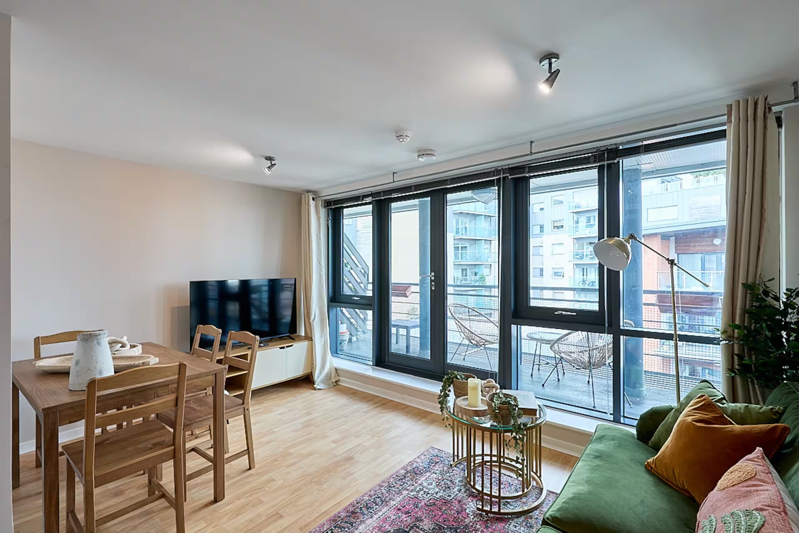 The apartment's living and dining space beside the balcony windows