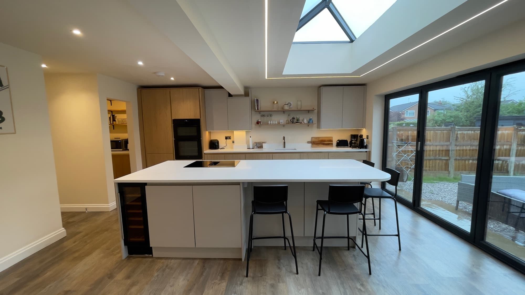 A newly fitted kitchen with an island and roof lantern, detail-cleaned after refurbishment