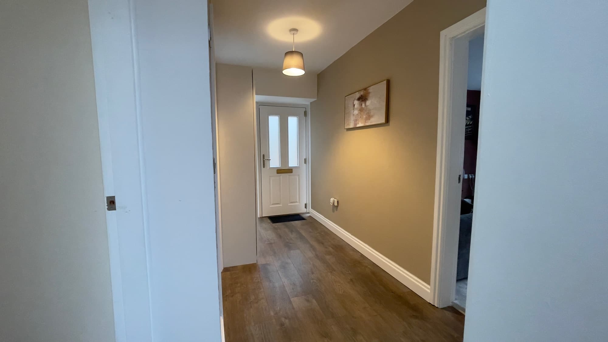 A cleaned hallway leading to the front door of a property at handover
